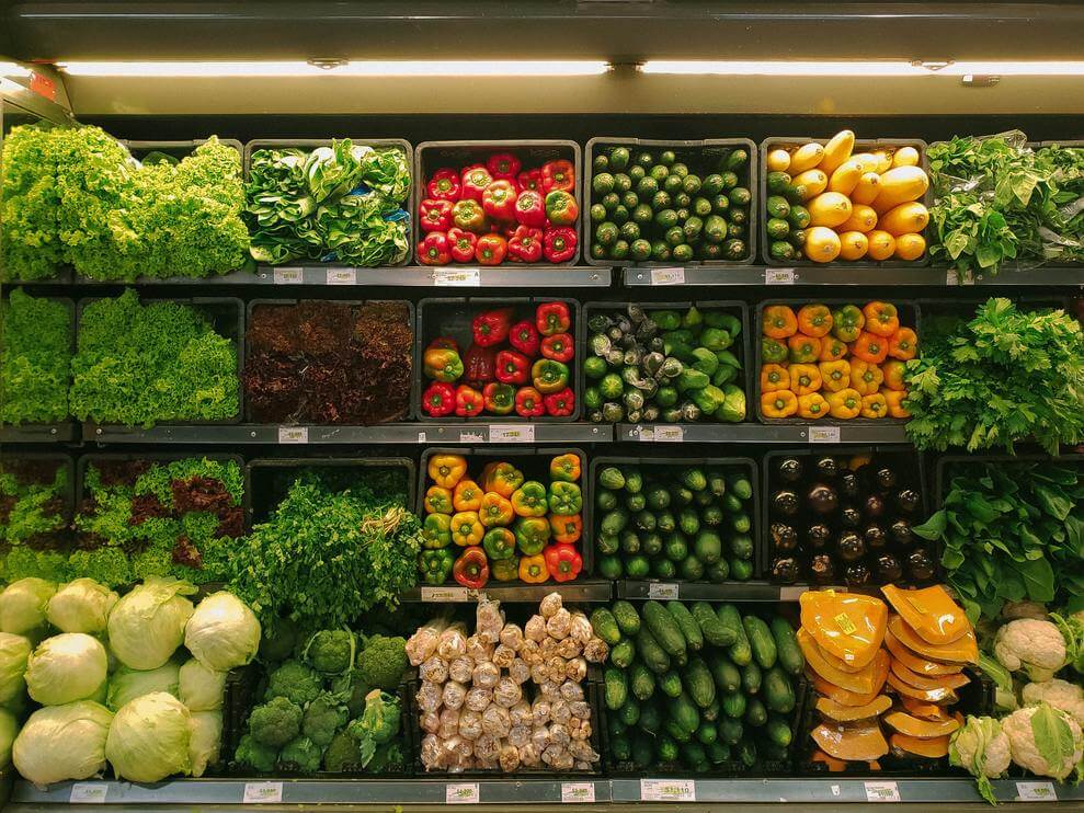 shelf of a grocery store containing vegetables
