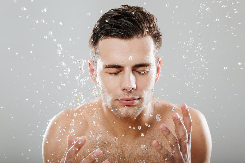 a man is washing his face. washing facial as well as whole body skin is vital step for men's skincare routines.