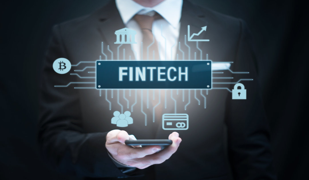 A person's hand with mobile and a logo in which fintech is written.